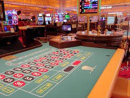 Layar permainan Monopoly Live dengan roda putaran dan papan Monopoly di latar belakang